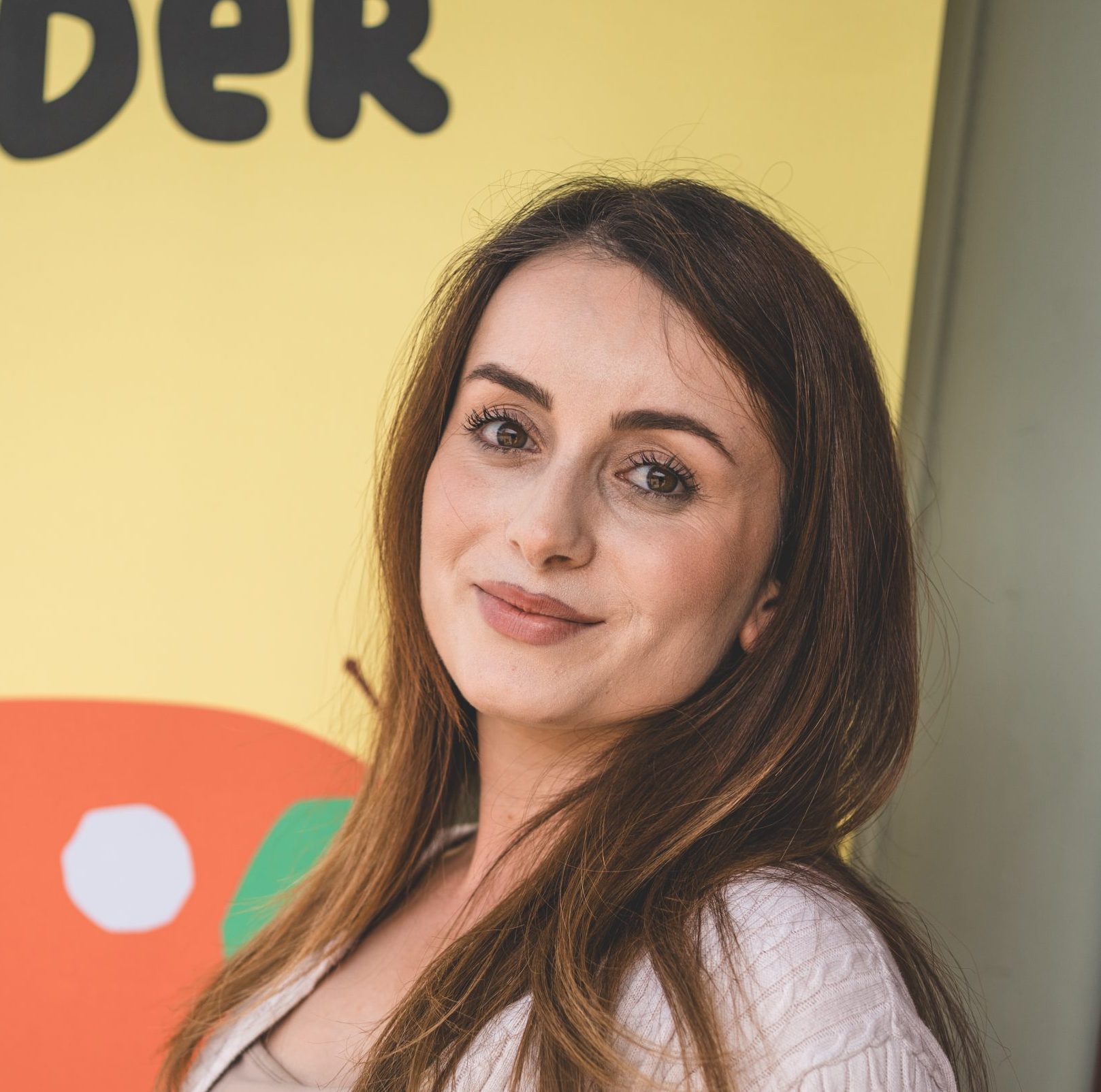 Portr&auml;tfoto von Tatevic vor einer bunten Wand mit Illustrationen